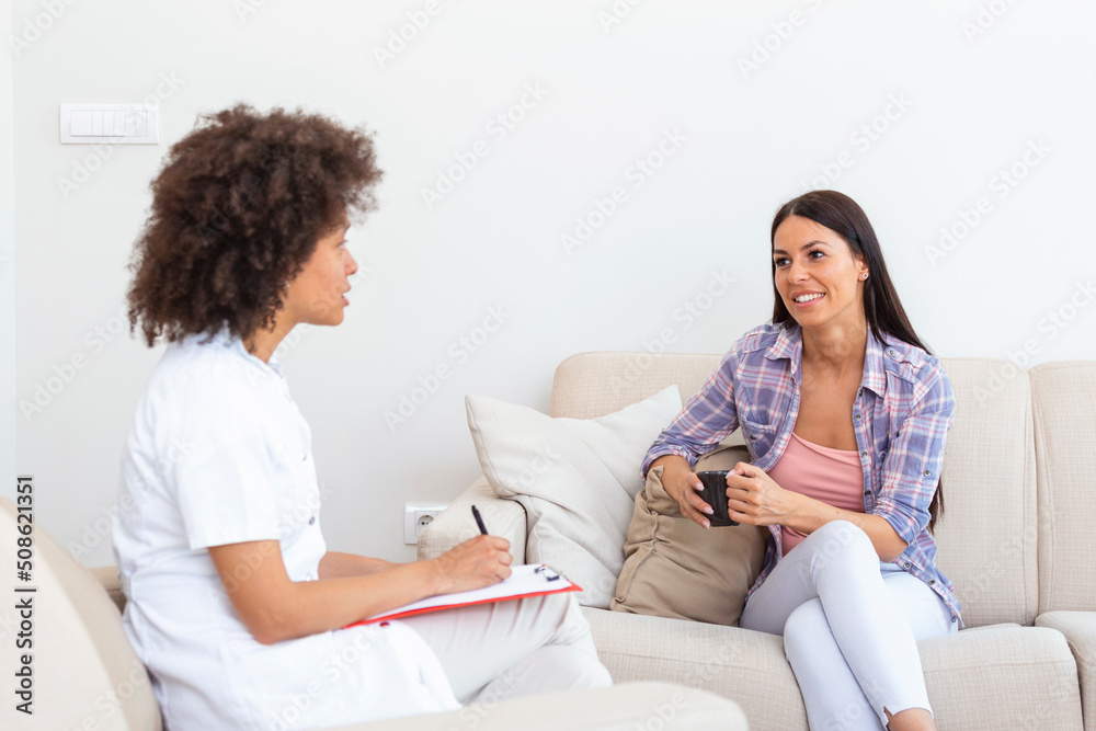 Woman at therapy session. Attentive psychologist. Attentive psychologist holding pencil in her hands making written notes while listening to her client Woman at therapy session. Attentive psychologist. Attentive psychologist holding pencil in her hands making written notes while listening to her client