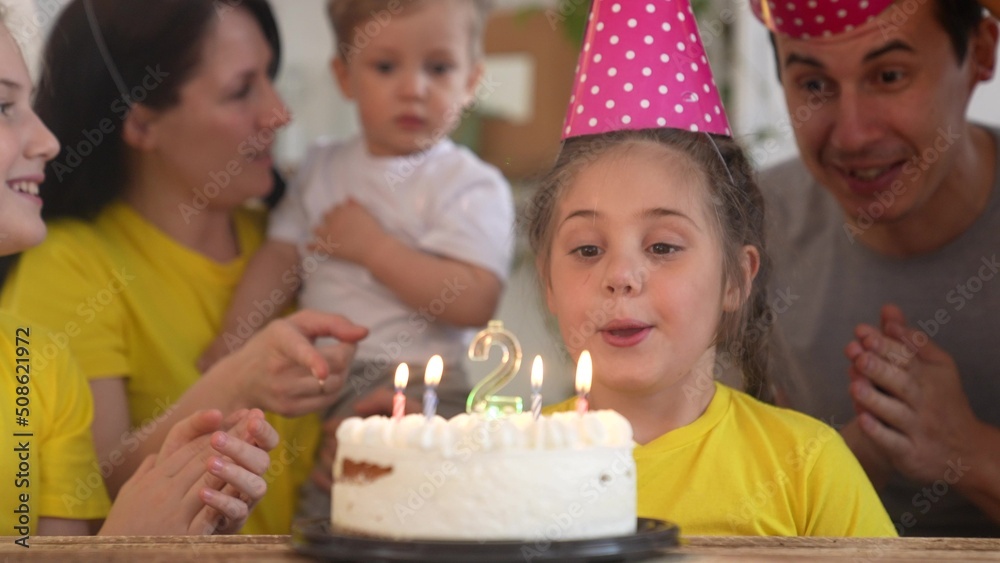 birthday. happy family on holiday party. parents and kids with baby getting ready to blow out birthday cake with candles. happy fun family at birthday. baby blows out the candles on the cake birthday. happy family on holiday party. parents and kids with baby getting ready to blow out birthday cake with candles. happy fun family at birthday. baby blows out the candles on the cake