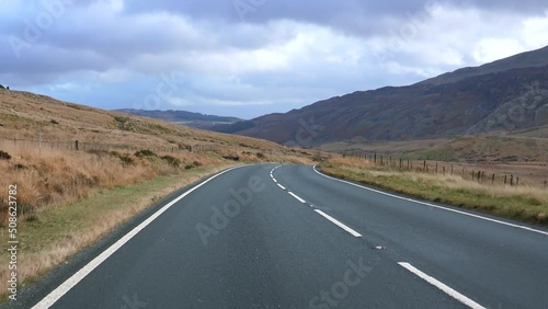 Traveling in beautiful Snowdonia National Park in autumn. Approaching slow tractor on A4086 road. photo