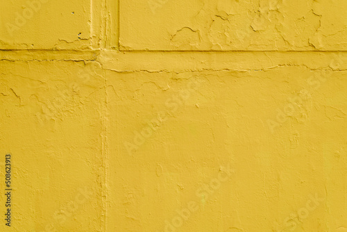 Saturated yellow rough texture background, bright paint on concrete slabs outdoors
