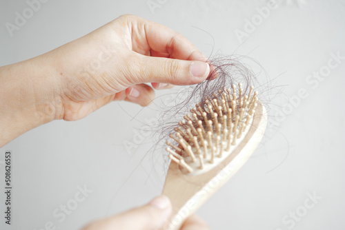  young women hold his list hair against white wall 