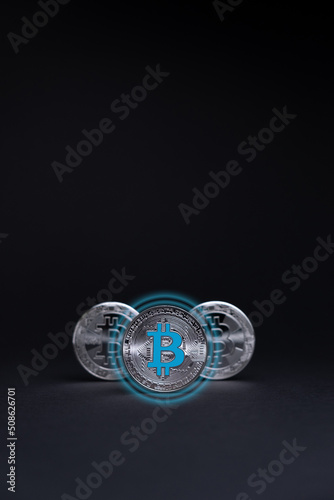 Silver Bitcoin coins currency. Crypto coin with glow circle effect, on a dark background. BTC International stock exchange. © Vitor Miranda