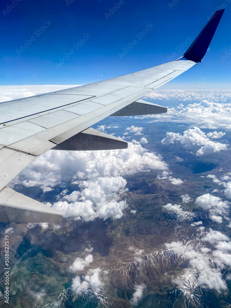 Fototapeta premium Clouds and airplane wing view from the plane window