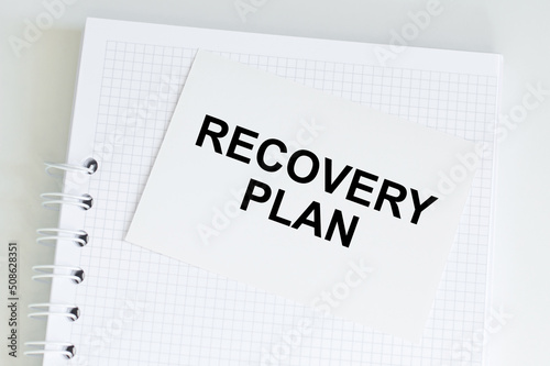 a white card with the RECOVERY PLAN. Financial concept