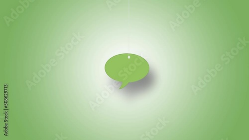 Speech bubble symbol in green hanged with strings against green background. High quality video in 4K resolution.