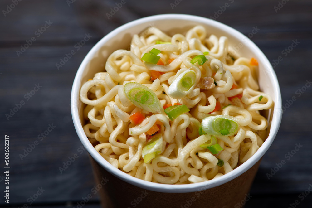 chinese fast food hot noodles in paper cup, top view closeup