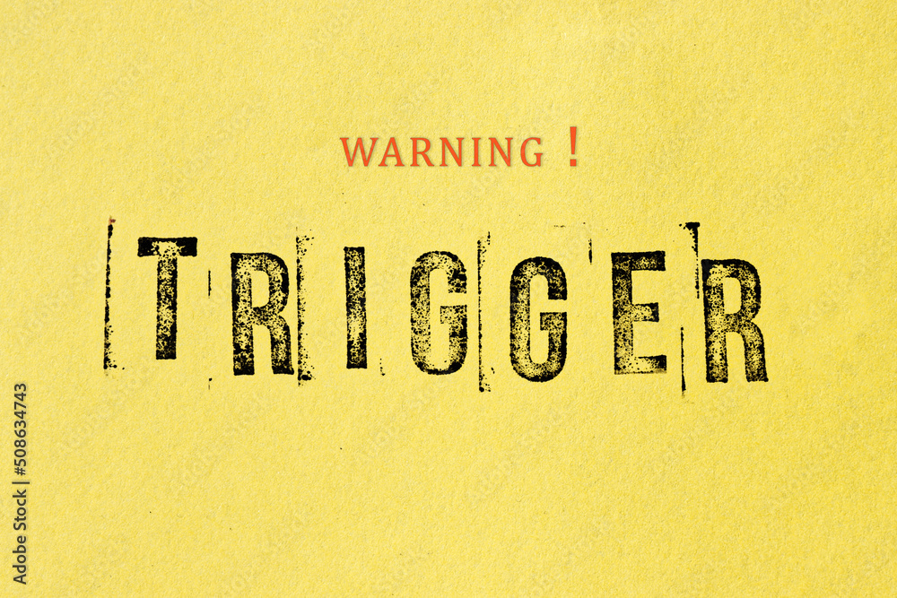 Trigger warning sign message on yellow background. Stamp letters mental