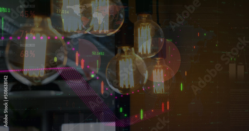 Image of financial data processing over lit light bulbs