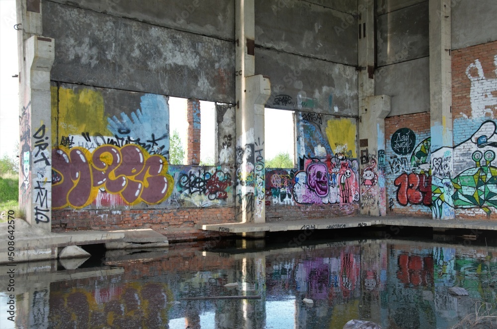 abandoned building with painted mills and flooded with water