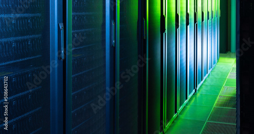 Image of empty corridor with row of blue and green computer servers