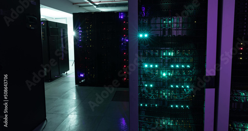 Image of empty corridor with rows of red and green lights in computer servers