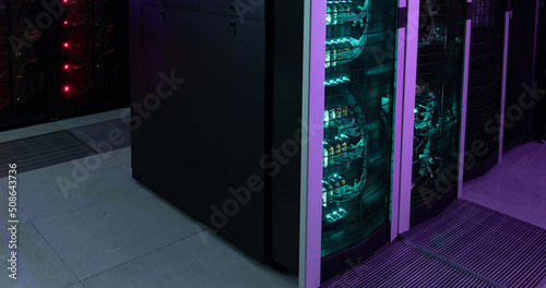 Image of empty corridor with rows of green and red in computer servers