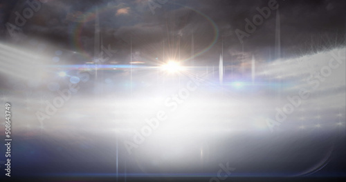 Image of blurred moving lights and bokeh light spots at floodlit sports stadium