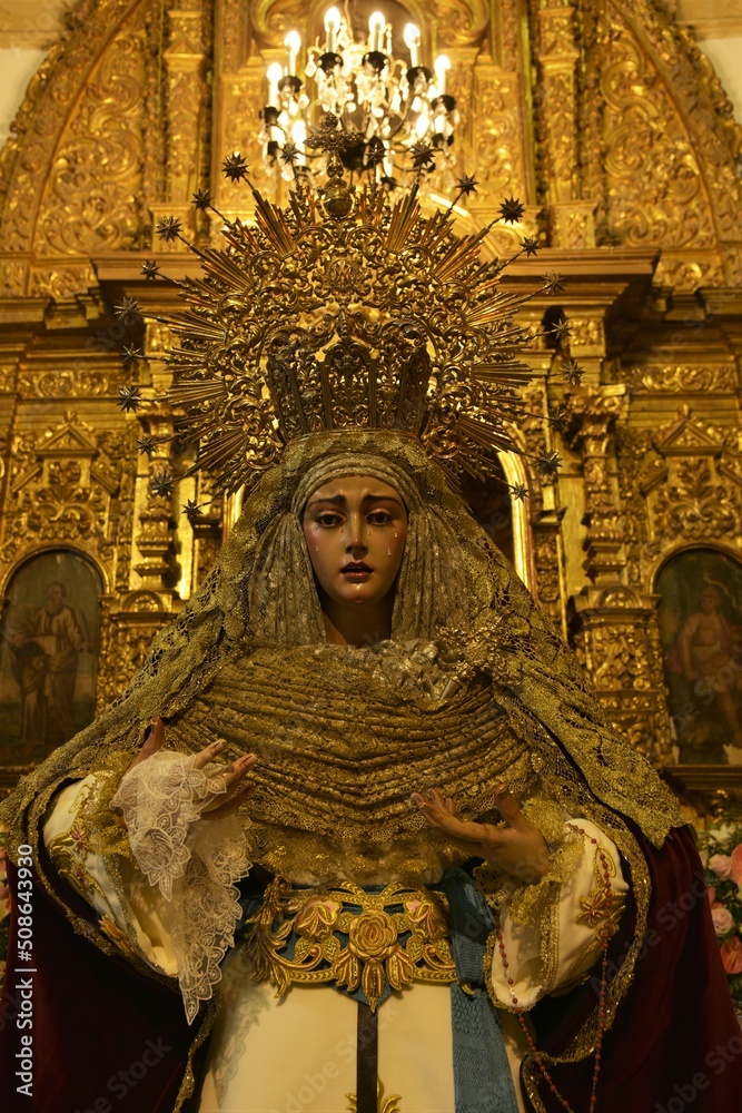 Obraz premium Beautiful life-size sculpture of the Virgin Mary in dramatic posture, adorned with rich clothing and jewelry at Iglesia Jesús Nazareno church, Chiclana de la Frontera, Spain