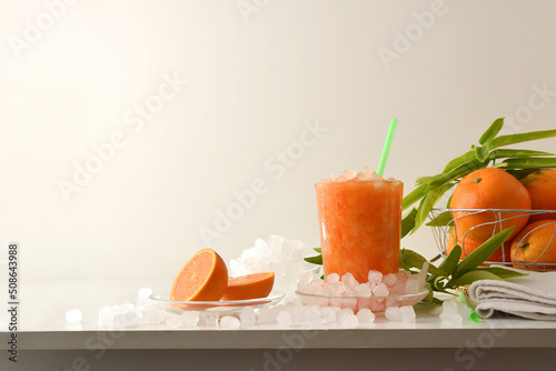 Detail of orange drink with ice on table isolated background
