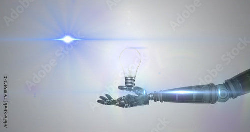 Image of illuminated light bulb over hand of robot arm, with blue light on grey background