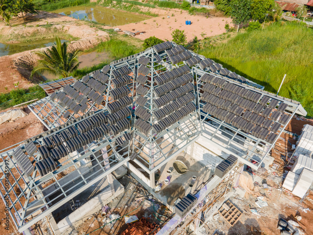 Aerial view of Concrete or CPAC cement roof tiles on the new roof are under construction. residential building. Infrastructure of the house at the construction site.