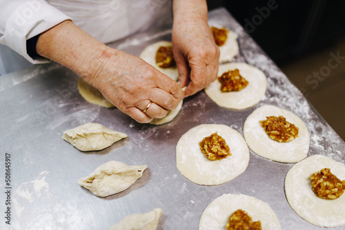 the cook with his hands works with the dough