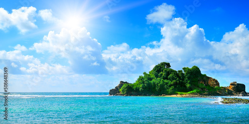 Tropical sea and sun on blue sky background. Wide photo.