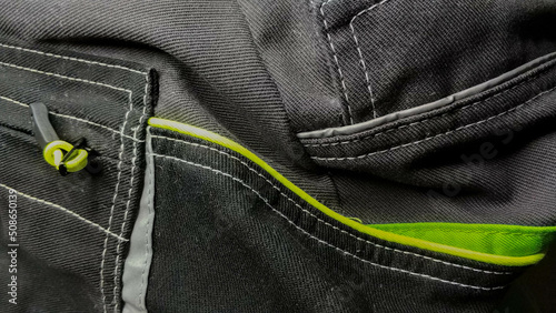 Texture of a black work uniform with green reflectors close-up photo