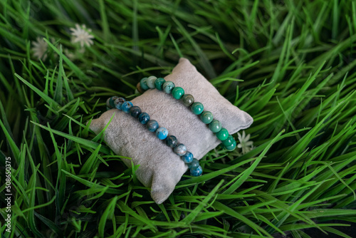 Two handmade bracelets, turquoise stones. On decorative green grass