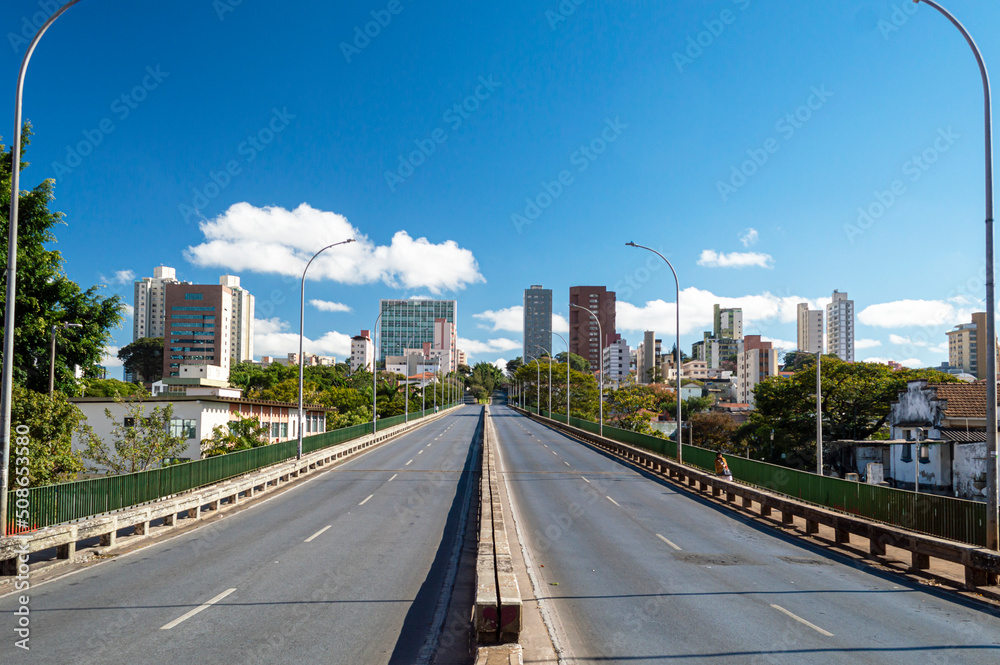 Obraz premium Viaduct, buildings and trees in the city of Belo Horizonte. Beautiful blue sky. Clouds.