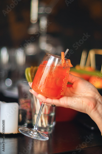 a cocktail glass in a woman's hand. close-up. bar