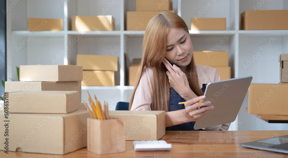 Small start-up business owners using computers and phones at work, salespeople, checking production orders. Pack products to ship to customers, sell ecommerce shipping ideas. Small start-up business owners using computers and phones at work, salespeople, checking production orders. Pack products to ship to customers, sell ecommerce shipping ideas.
