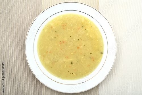 Homemade chicken cream soup with a lot of different spices in the white plate. Top view. Healthy diet concept.