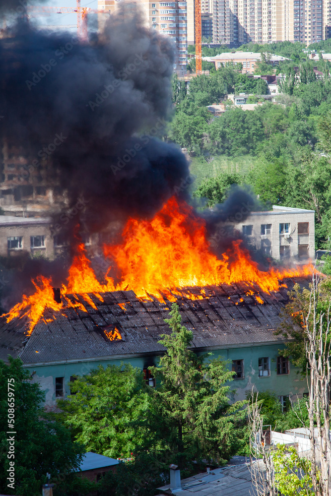 A fire in an old abandoned house, a view from the window of a neighboring high-rise building
