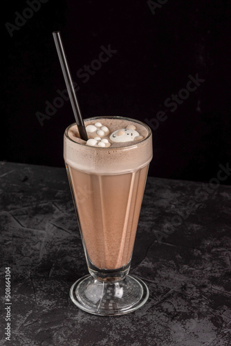 cocoa drink decorated with funny cookies on a dark background