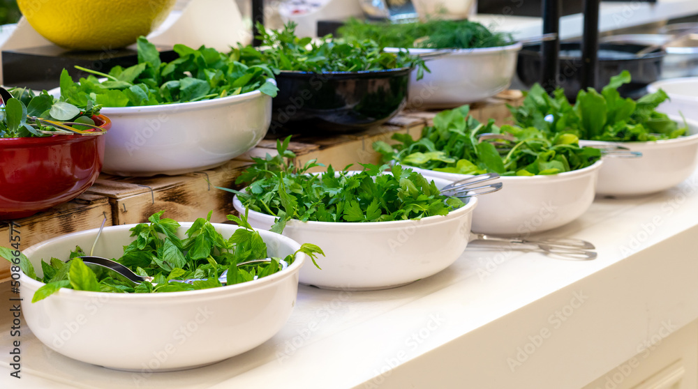Salad bar with fresh greens in hotel buffet. Concept of healthy eating