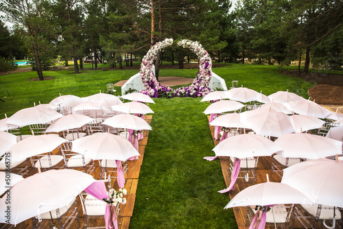 Outdoor wedding ceremony with umbrellas in the forest