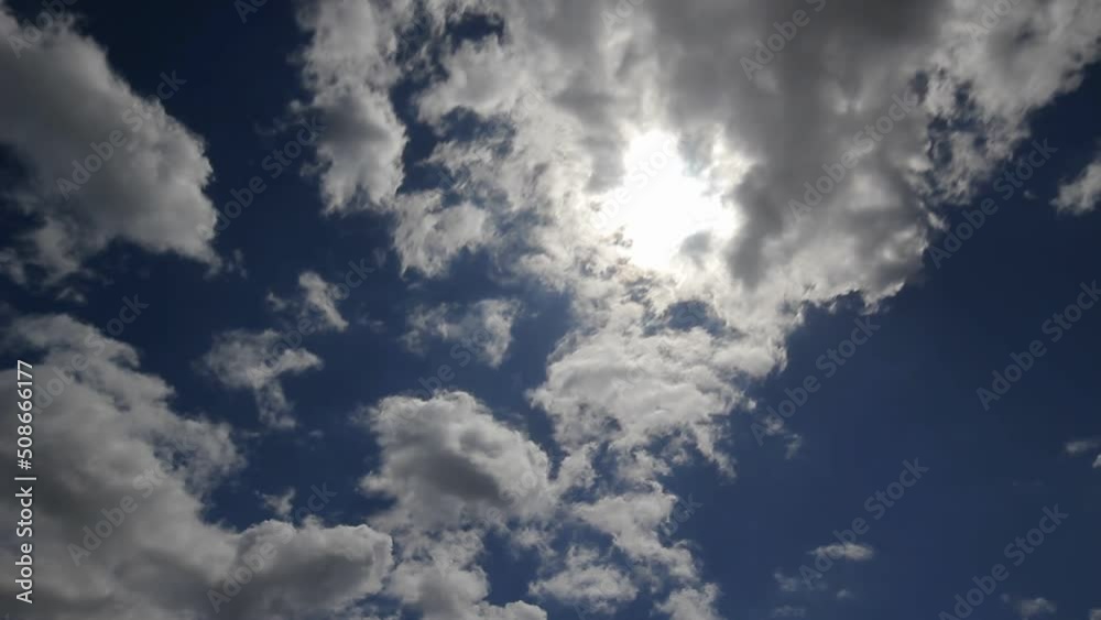 Rapid movement of white clouds. Timelapse of fast moving clouds. Fast moving and changing shape of clouds against a blue sky
