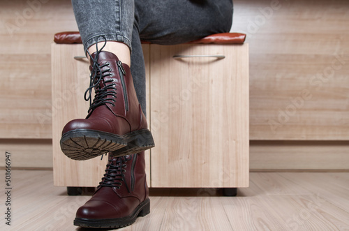 Closeup of woman legs in red leather boots and black jeans