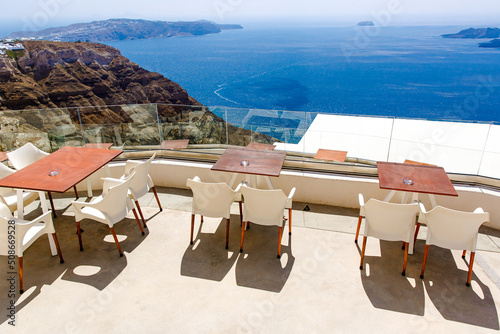 View of the Aegean sea from Santorini island with table and seats in the foreground, Greece. Greek landscape © 9parusnikov