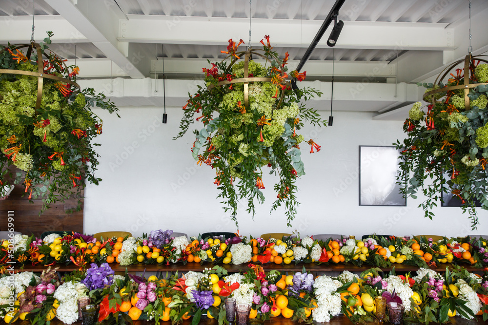 Naklejka premium Bouquets of flowers and fruits in vase on the wedding table