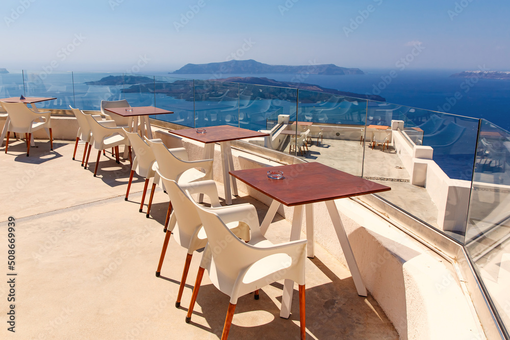 View of the Aegean sea from Santorini island with table and seats in the foreground, Greece. Greek landscape