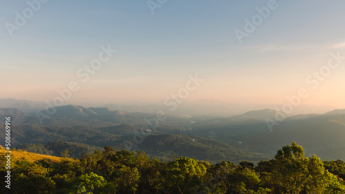 Cardamom hills under clear sky with mist on horizon at sunset in Thekkady, India. © Daniel