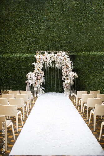 Outdoor wedding ceremony in the garden near green wall