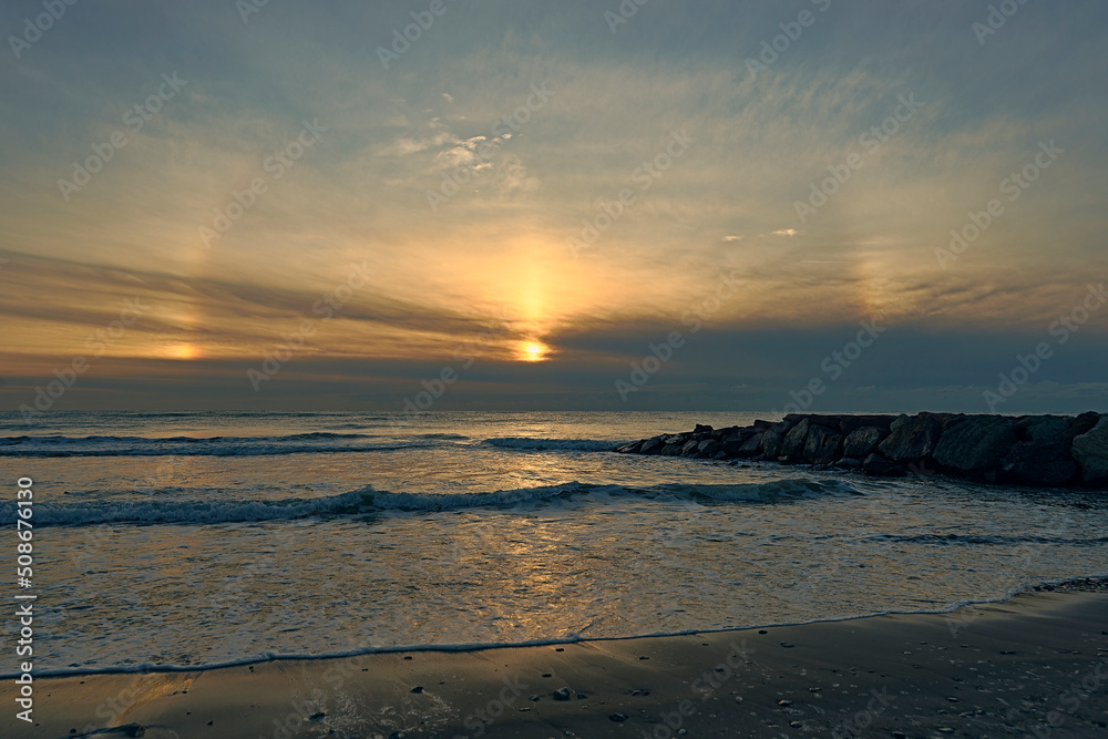 Sunrise from the beach with a breakwater Sunrise from the beach with a breakwater
