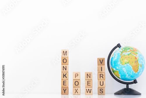 Monkey pox word is written on wooden cubes on a white background. Closeup of wooden elements photo