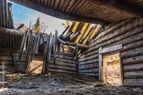 Inside of an abandoned log cabin building with roof collapsed in Fototapet