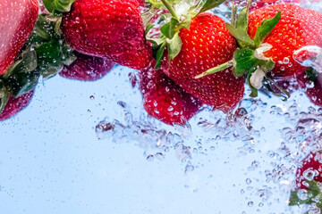 Crédence de cuisine  Strawberries in water with water splash and air bubbles on blue background. Close up image.  © Natia