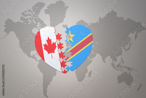 puzzle heart with the national flag of canada and democratic republic of the congo on a world map background.Concept.