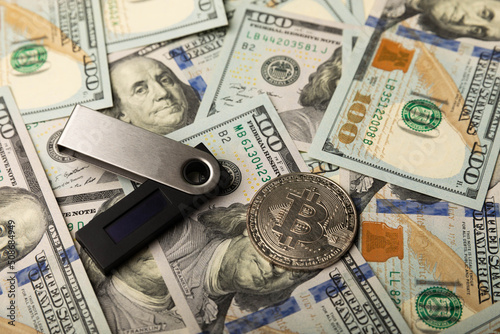 Cryptocurrency cold wallet and one hundred dollar banknotes.Business concept.Currency saving. Investment.Cryptocurrency.Bitcoin digital currency.Crypto coin currency storage business concept.