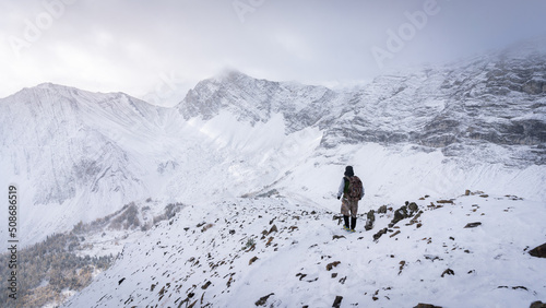 Hiker descending from the mountain during winter, narrow shot, Kananaskis, Canada