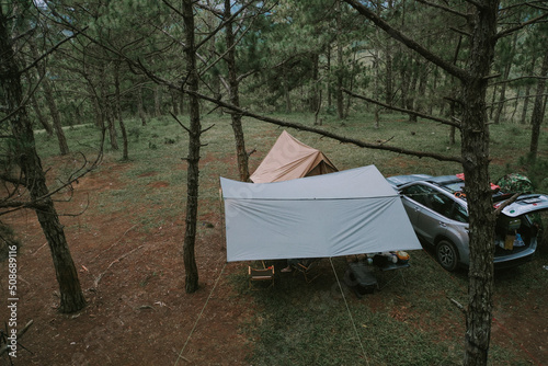 Aerial view. Group of friends sitting outside enjoying, relaxation nature on the hills in the twilight. Travel, tour adventure on nature, vacation and friendship, happy camper. Friends camping sitting