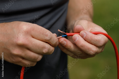 Hands splicing electrical wires together