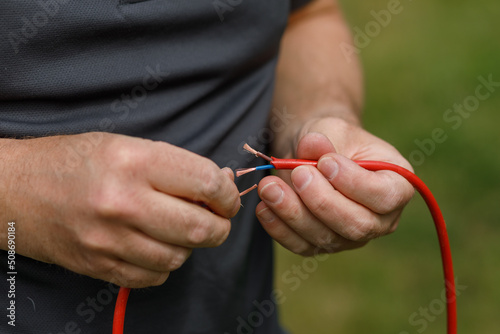 Canvastavla Severed electrical wires held in a mans hands, ready to be connected